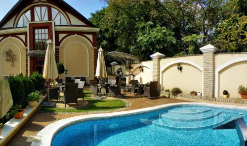 een zwembad voor een huis bij Hotel Vila Lago in Palić