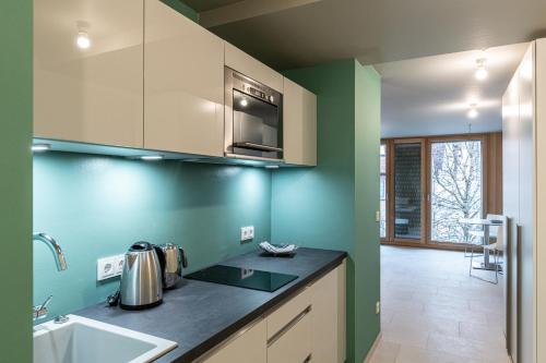 a kitchen with green walls and a counter top at WEST Apartments in Schorndorf