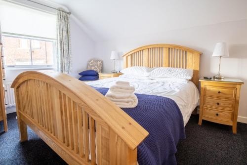 a bedroom with a large bed with a wooden frame at Number Seven Cottage in Whitby