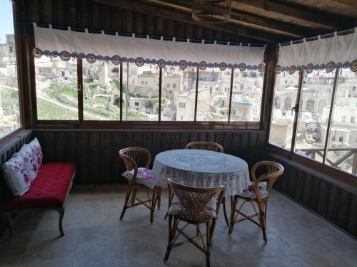 a table and chairs in a room with windows at patisca cave house in cappadocia in Ürgüp