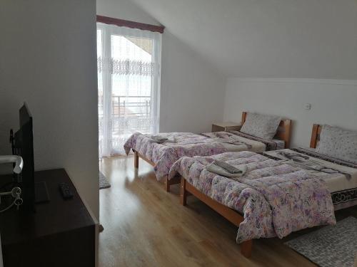 um quarto com duas camas e uma janela em Shoposki Guest House em Elshani