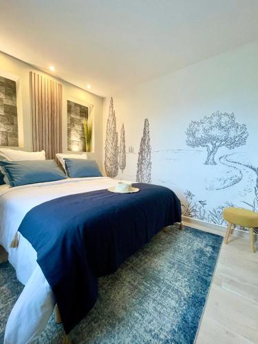a bedroom with a large bed with a blue blanket at Bastide Beaudinard in Aubagne