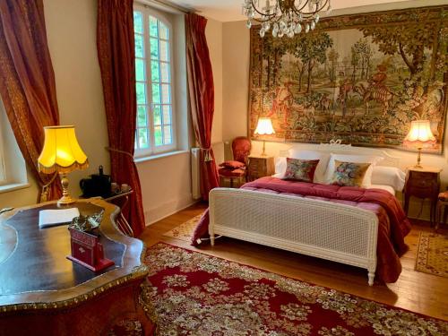 sypialnia z łóżkiem i dużym obrazem na ścianie w obiekcie Château Ratou w mieście Saint-Lys
