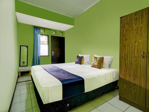 1 dormitorio con 1 cama grande con sábanas y almohadas blancas en OYO Life 91116 Pelangi Residence Syariah, en Jatiroke