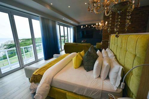 a large bedroom with a large bed with yellow pillows at Hermanus Boutique Guest House in Hermanus