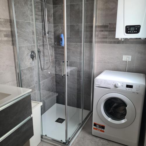 a washing machine in a bathroom with a shower at CHIOGGIA VENICE APARTMENT in Chioggia