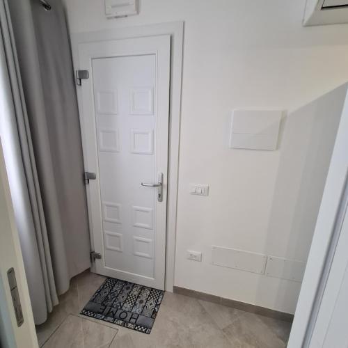 a hallway with a white door and a rug at CHIOGGIA VENICE APARTMENT in Chioggia