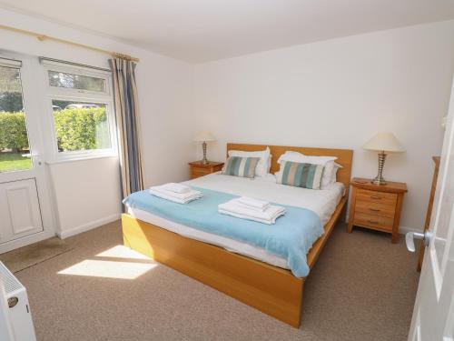 a bedroom with a large bed and a window at 8 Munday Cottages in Yarmouth