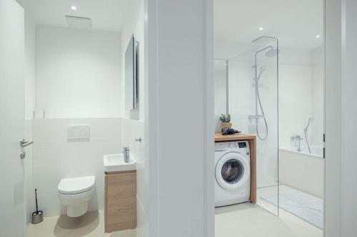 uma casa de banho com um WC e uma máquina de lavar roupa em Ideal for Families & Mid-Term-Stays em Viena
