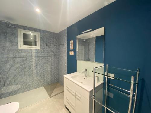 La salle de bains est pourvue d'un lavabo et d'un mur bleu. dans l'établissement Ático en Javea pueblo “Patraix”, à Jávea