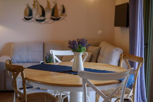 a dining room table with a vase of flowers on it at Comfeto & Mandolato Sweet Houses in Lakithra