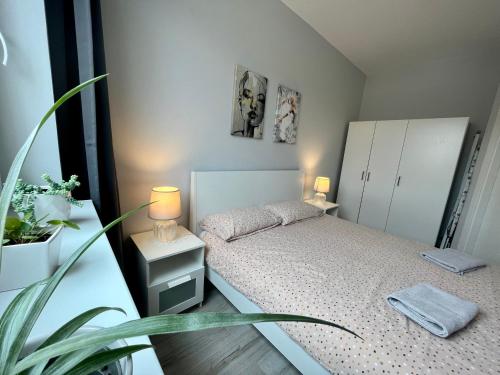 - une petite chambre avec un lit et une plante dans l'établissement Apartament Spa - sauna i garaż w cenie, à Ełk