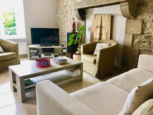 un salon avec deux canapés et une télévision dans l'établissement Moulin du pont neuf Maison des Meuniers, à Le Vieux-Marché