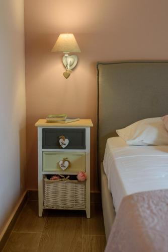 a bedroom with a bed and a nightstand with a lamp at Comfeto & Mandolato Sweet Houses in Lakithra