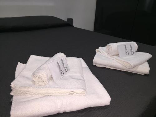 two stacks of towels sitting on top of a bed at Solemare Beach Apartment Trapani in Erice