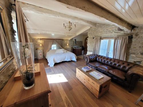 a living room with a couch and a bed at Le Clos de l'Ambre in Divajeu