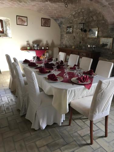 a dining room with a long table and white chairs at B&b La Baronata - Pescosansonesco (Pe) in Pescosansonesco