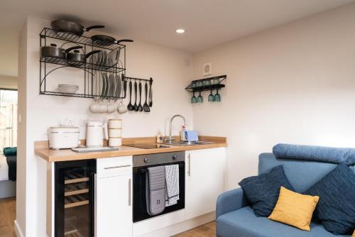 una pequeña cocina con una silla azul y un fregadero en The Garden House, en Shrewsbury