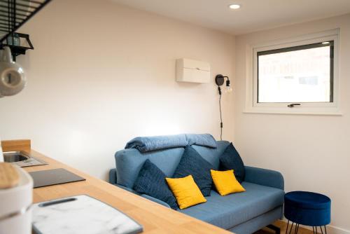 a blue couch with two yellow pillows in a room at The Garden House in Shrewsbury