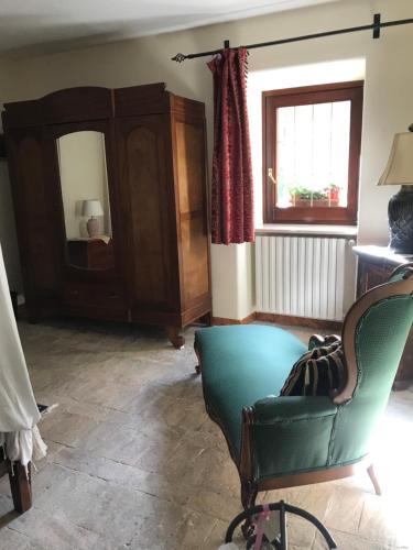 a living room with a chair and a mirror at B&b La Baronata - Pescosansonesco (Pe) in Pescosansonesco