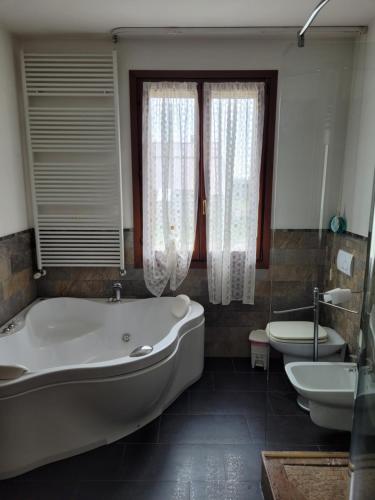 a bathroom with a tub and a toilet and a sink at Maddy Appartamento in Porto Viro