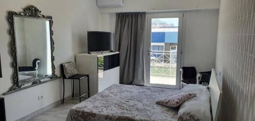 a bedroom with a bed and a mirror and a window at alhena room in Terracina