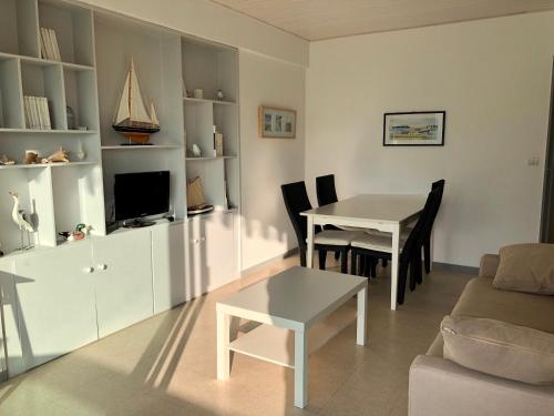 a living room with a table and a dining room at JARDIN 308 Appartement avec Terrasse et Parking in Arcachon
