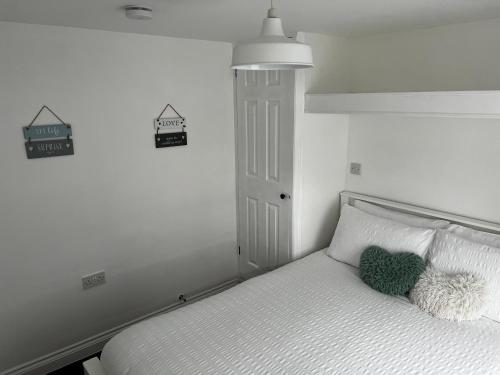 Un dormitorio con una cama con una almohada verde. en Surfs Up Lodge - Westward Ho!, en Westward Ho