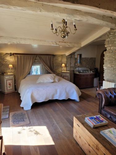 a bedroom with a bed and a couch in a room at Le Clos de l'Ambre in Divajeu