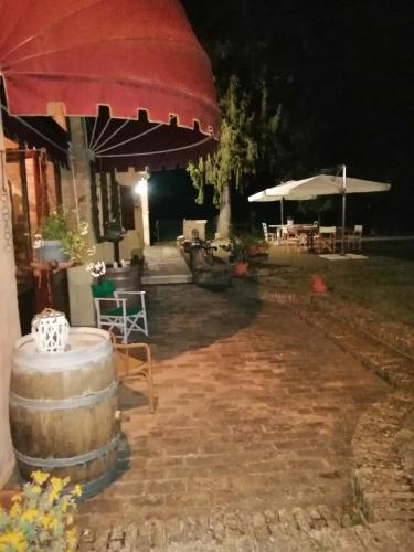 a patio at night with a barrel and umbrella at B&B FETONTE in Crespino