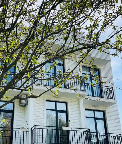 a white house with windows and a balcony at Villa Flora in Gonio