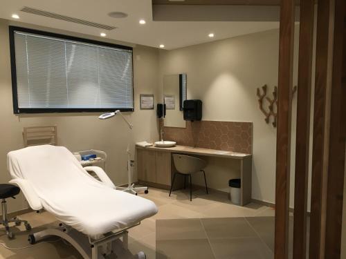 a hospital room with a white chair and a desk at DOMITYS L'ESTAMPE in Romans-sur-Isère