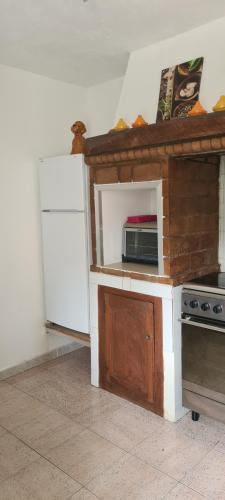 une petite cuisine avec un micro-ondes et un réfrigérateur dans l'établissement maison de village T4, à Poggio-dʼOletta