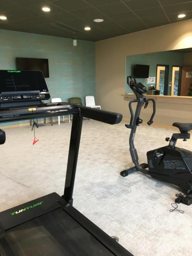 a room with a gym with a treadmill and a desk at DOMITYS L'ESTAMPE in Romans-sur-Isère