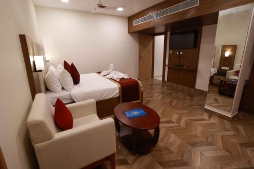 a hotel room with a bed and a couch and a table at HOTEL BLUEMOON in Tirunelveli