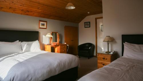 a hotel room with two beds and a chair at Ben Breen House B&B in Clifden