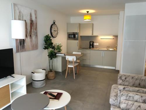 a living room with a couch and a table at DOMITYS L'ESTAMPE in Romans-sur-Isère