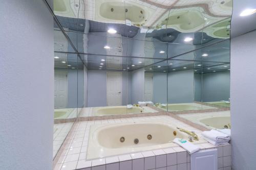 a large bathroom with a tub and two sinks at Pigeon Forge Parkway Inn in Pigeon Forge