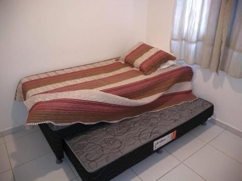 a small bed in a room with avertisement at Meu Cantinho na Praia do Frances in Marechal Deodoro