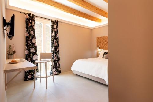 um quarto com uma cama, uma mesa e uma janela em La VIA Rooms and Terrace em Olbia