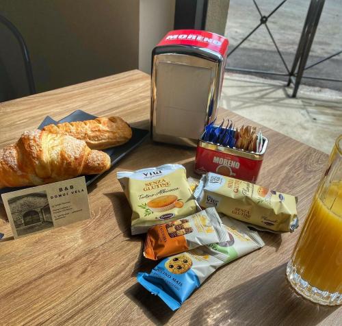 a table with bread and snacks and a drink at DOMUS VELA in Fornelli