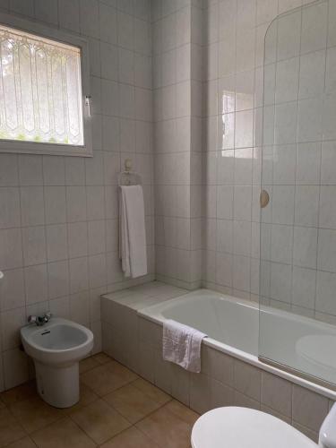 a bathroom with a tub and a toilet and a sink at A lastra in Villamartín