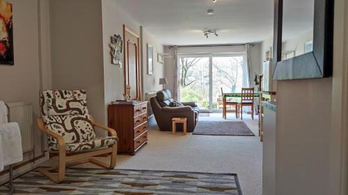 a living room with a couch and a chair at Wood Bank Studio Apartment in Holmfirth