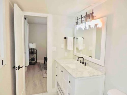 een witte badkamer met een wastafel en een spiegel bij Modern getaway! Relax, bike, hike, and shred! in Angel Fire