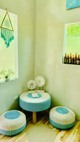 two tables and two stools in a room with bottles at Hidden of Cailan Inn in El Nido