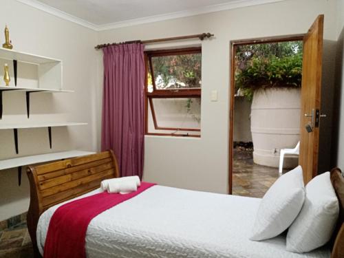 a bedroom with a bed and a window at Uyolo Guest Logde in Port Elizabeth