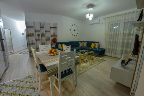 a living room with a table and a blue couch at Denis Comfort Apartment in Shkodër