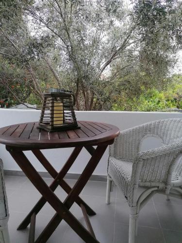 a wooden table and two chairs on a patio at Detached renovated cottage with a garden 3 min walk from the beach in Vrahati