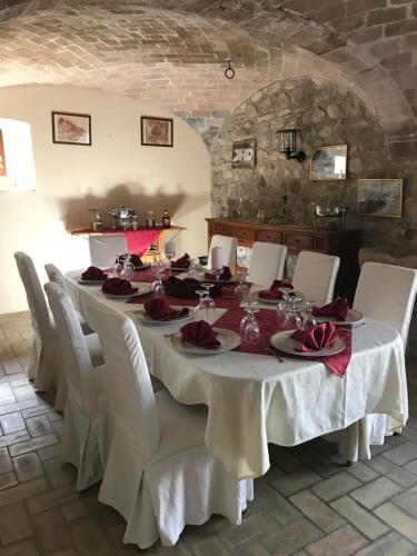 a dining room with a long table and white chairs at B&b La Baronata - Pescosansonesco (Pe) in Pescosansonesco