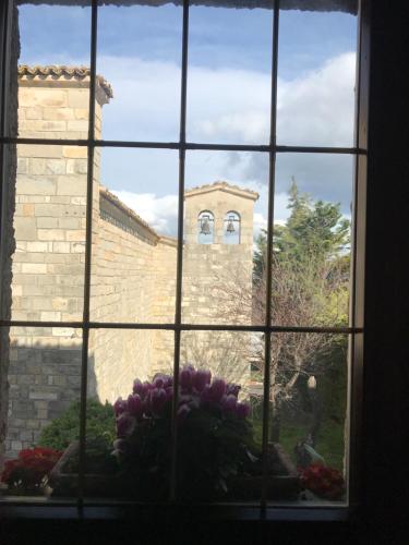 a window with a view of a building through it at B&b La Baronata - Pescosansonesco (Pe) in Pescosansonesco